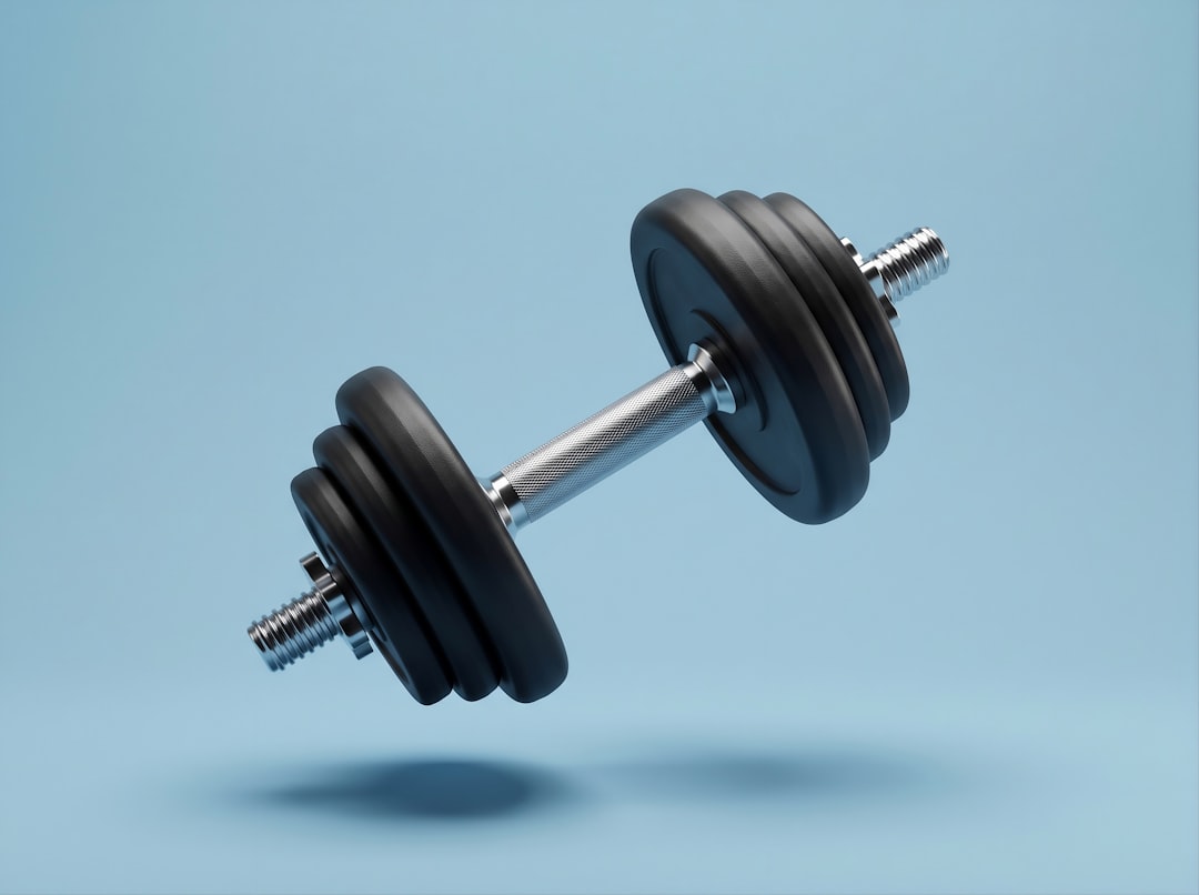 A chrome dumbbell with black weights floating on blue background
