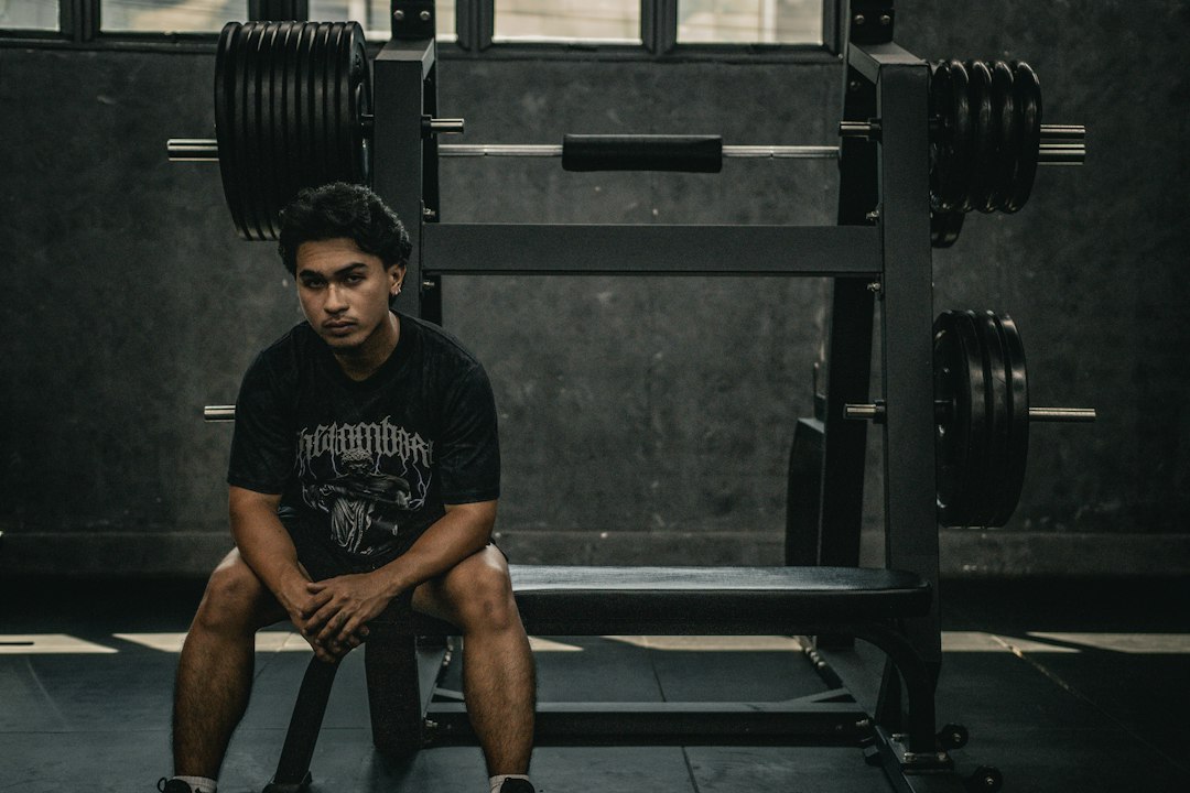 A man sitting on a bench in a gym