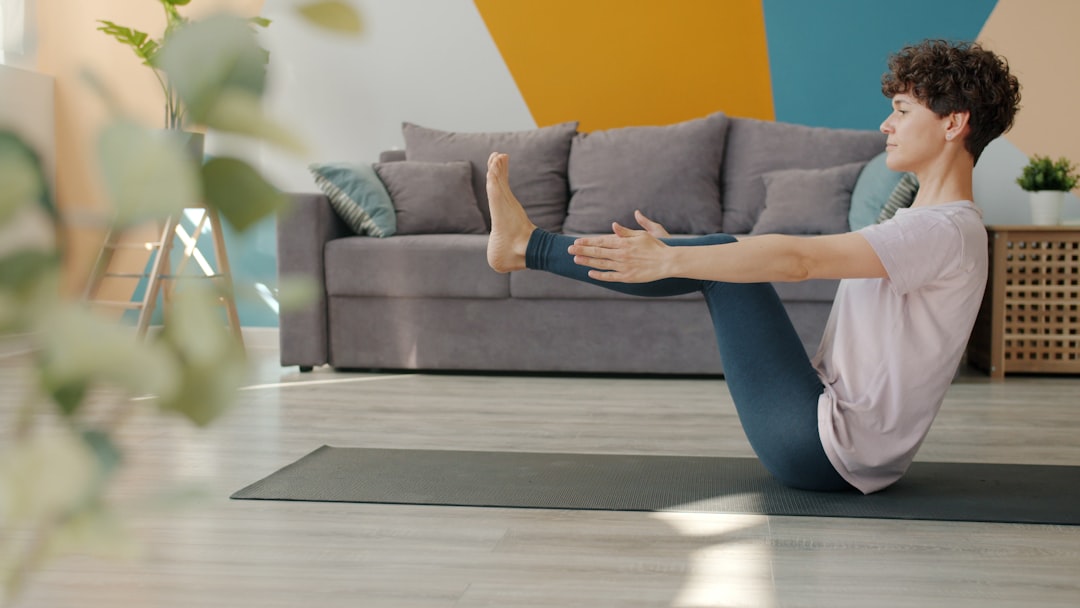 Woman doing yoga boat pose on mat at home
