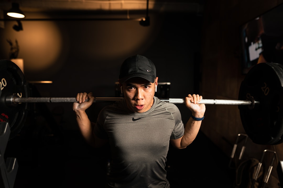 a woman lifting a barbell in a dark room