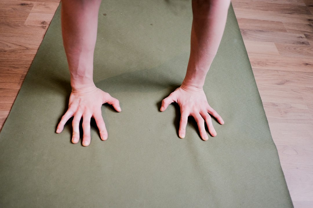 a person with their hands on a mat
