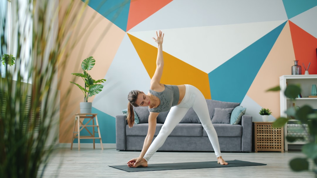Woman practicing triangle pose yoga at home