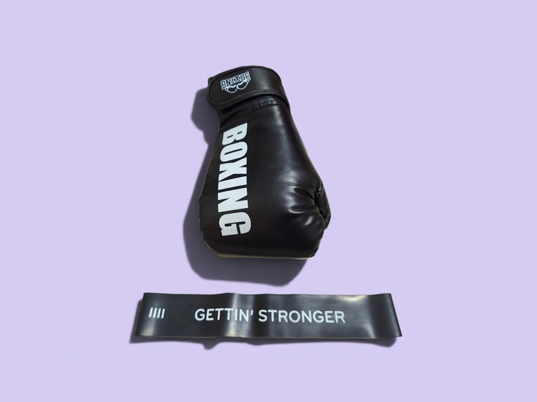 Black boxing glove and "gettin' stronger" resistance band on purple