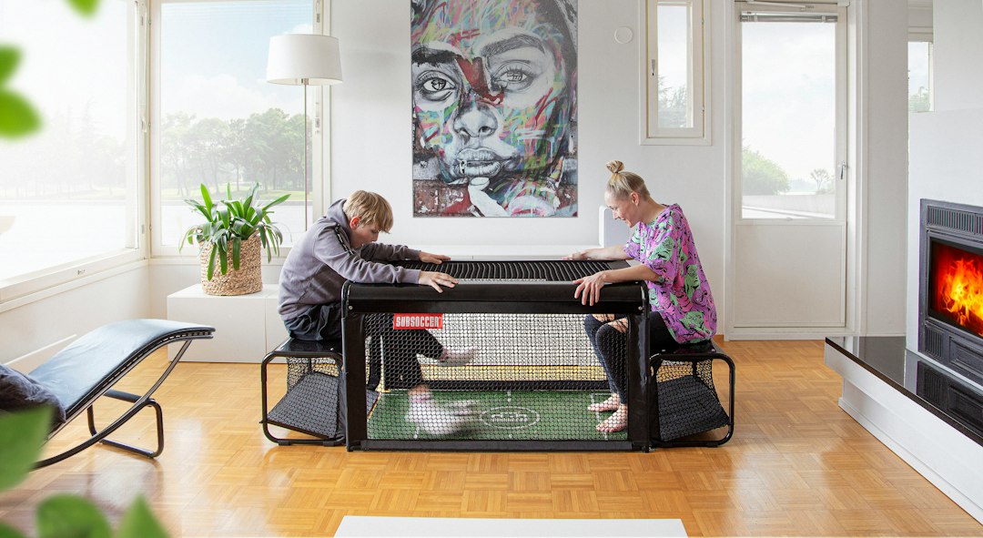 Two people playing foosball in a living room